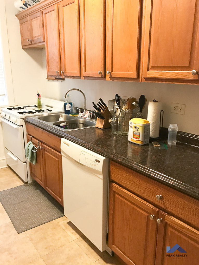 a kitchen with wooden cabinets and a white dishwasher and sink